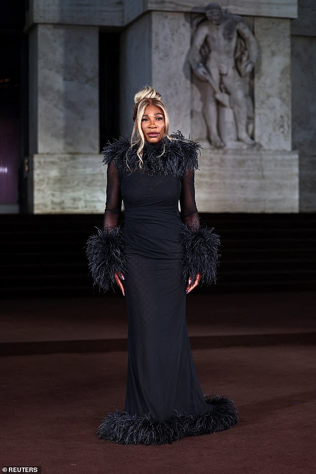 Serena Williams put on a glamorous display in a figure-hugging black mesh gown with long sleeves trimmed with feather cuffs