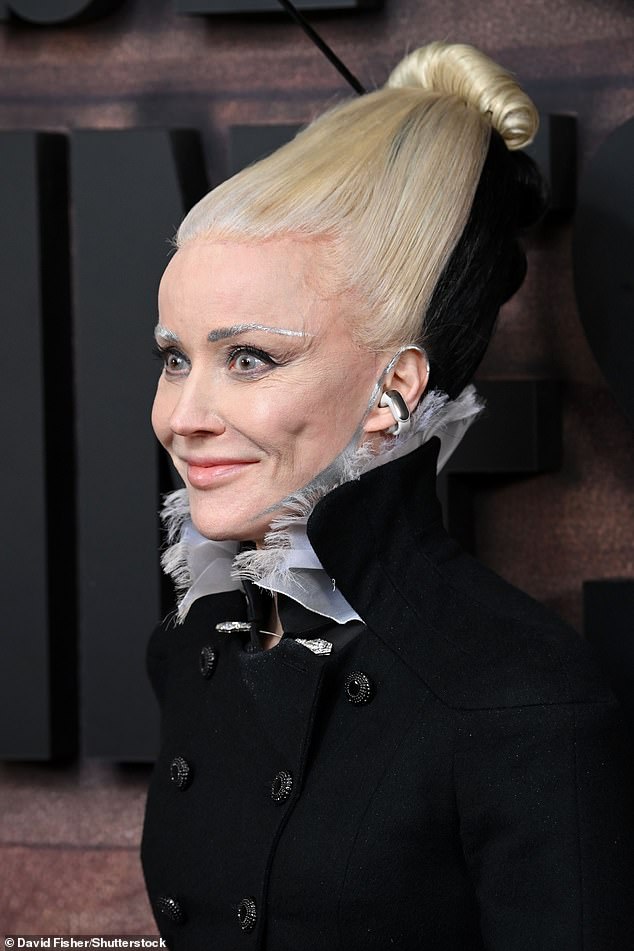 She added to the avant-garde look by sporting a quirky metallic glove on one hand and painting silver stripes over her eyebrows, ears and down her jawline