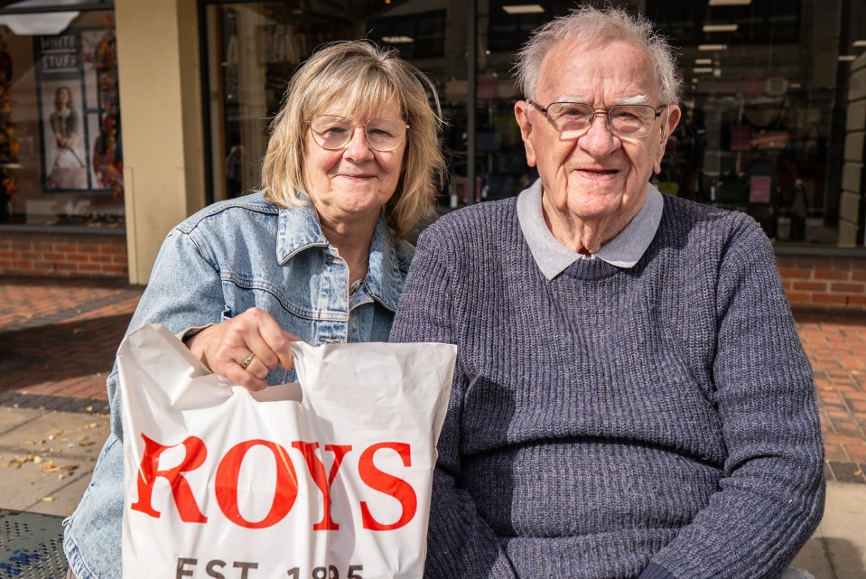 Dianne and Derek with a shopping bag from Roy's of Wroxham.