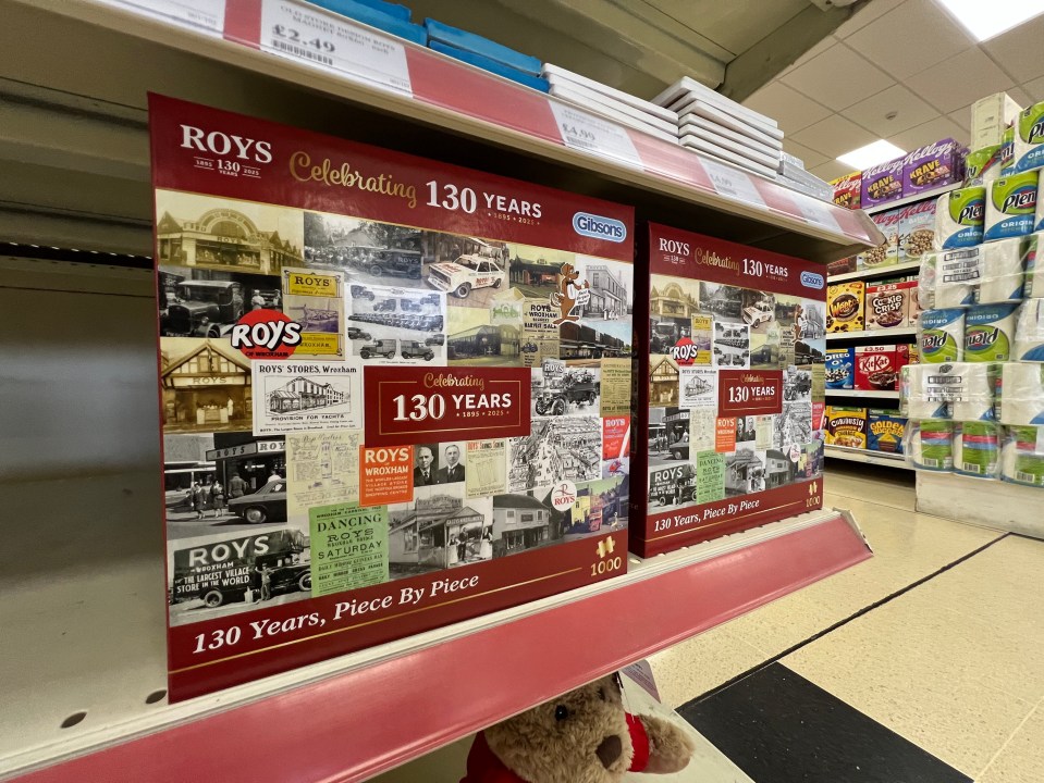 Two Roy's of Wroxham themed jigsaw puzzles celebrating 130 years on a store shelf.