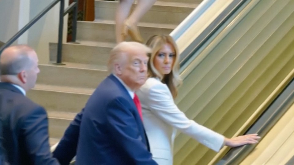 Donald Trump and Melania Trump on an escalator that has stopped.