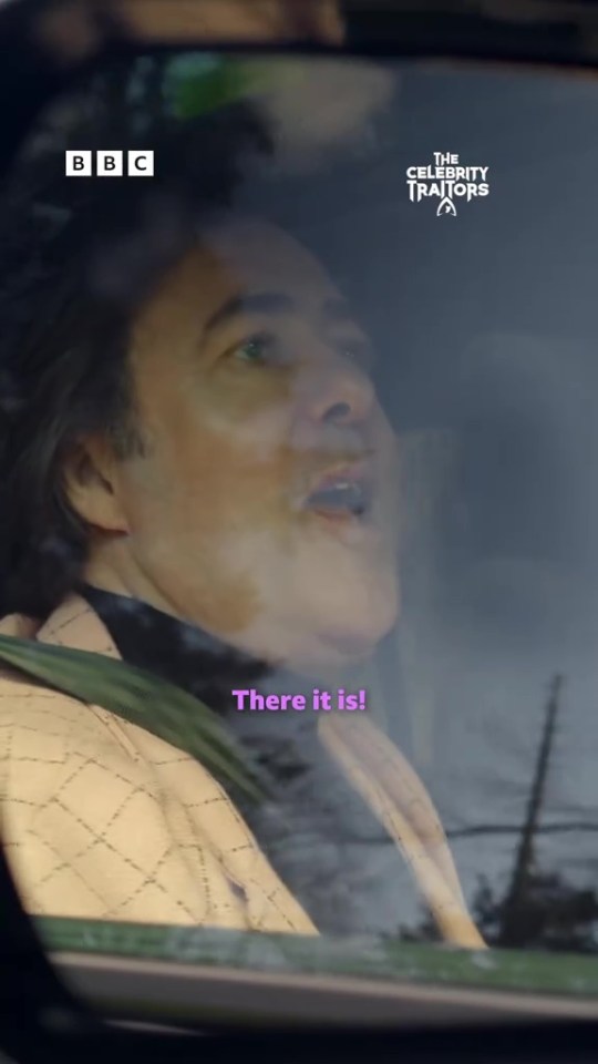 Jonathan Ross inside a car, looking out and saying, "There it is!" with BBC and The Celebrity Traitors logos visible.