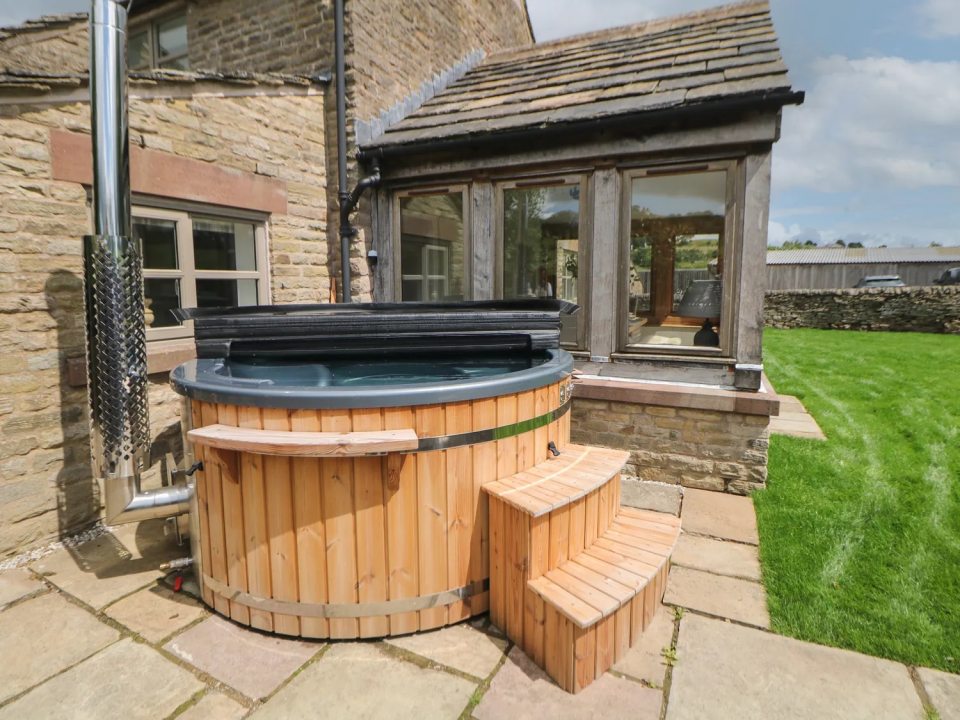Stag Cottage with a hot tub on a stone patio.