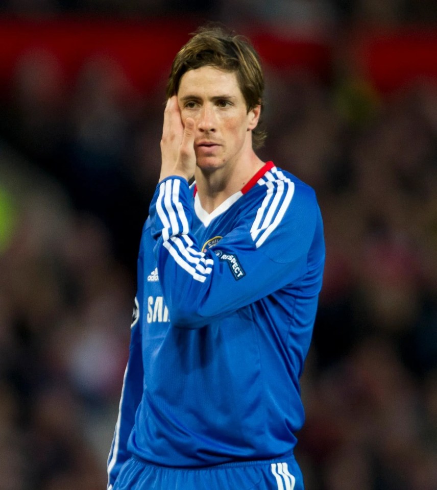 Fernando Torres in a blue Chelsea uniform with his hand on his face during a match.