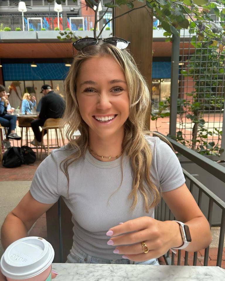 Olivia Peet, a rising British tennis star, sitting outdoors with a coffee.
