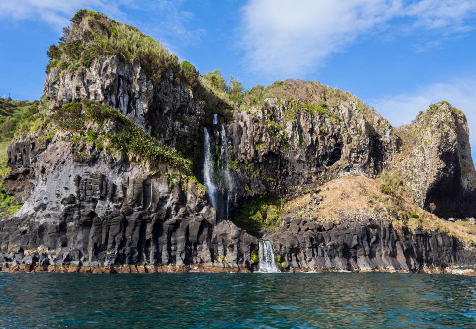 Rocky coastline with waterfalls near Ponta Delgada on Flores Island in the Azores.
