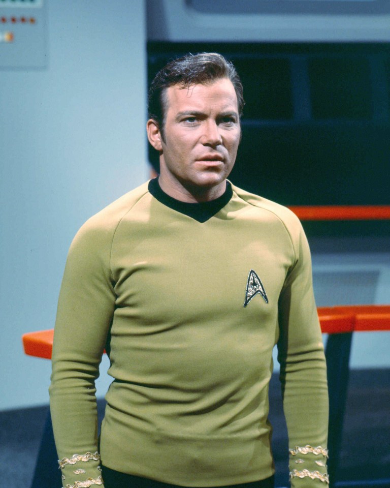 William Shatner as Captain James T. Kirk in a green uniform from Star Trek.