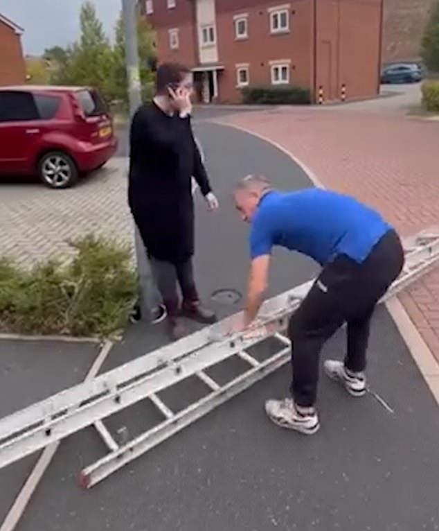 The woman initially stood in front of the lamppost to try and prevent the flag being attached