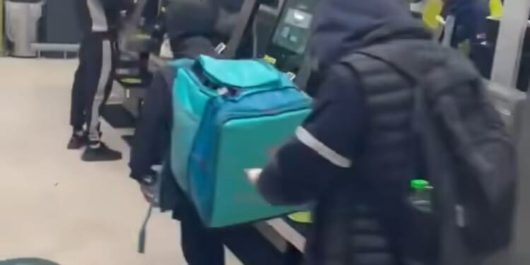 Shock moment shoplifters load bag with bottles of booze at Waitrose as hapless 'security guard' stands next to them