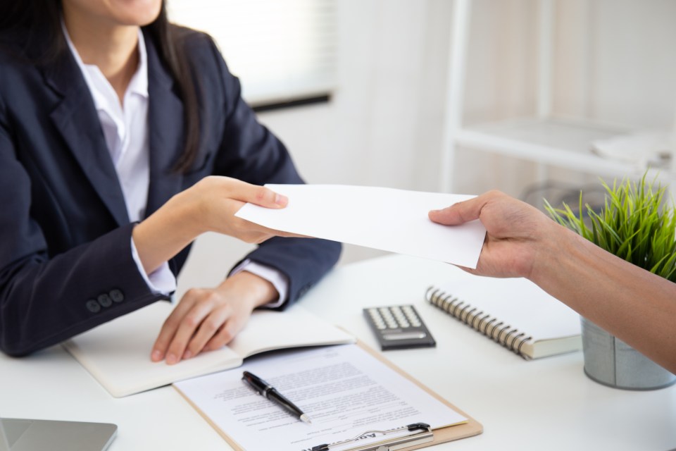 Asian businesswoman happily receiving salary or bonus from her boss or manager.