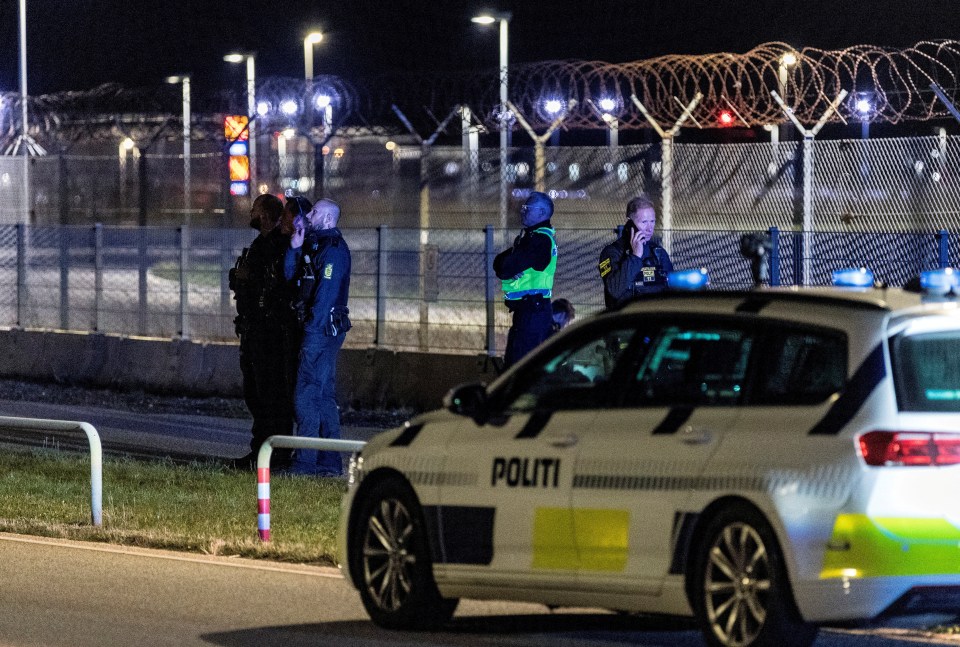 Police officers standing guard at Copenhagen Airport after traffic closure due to drone reports.
