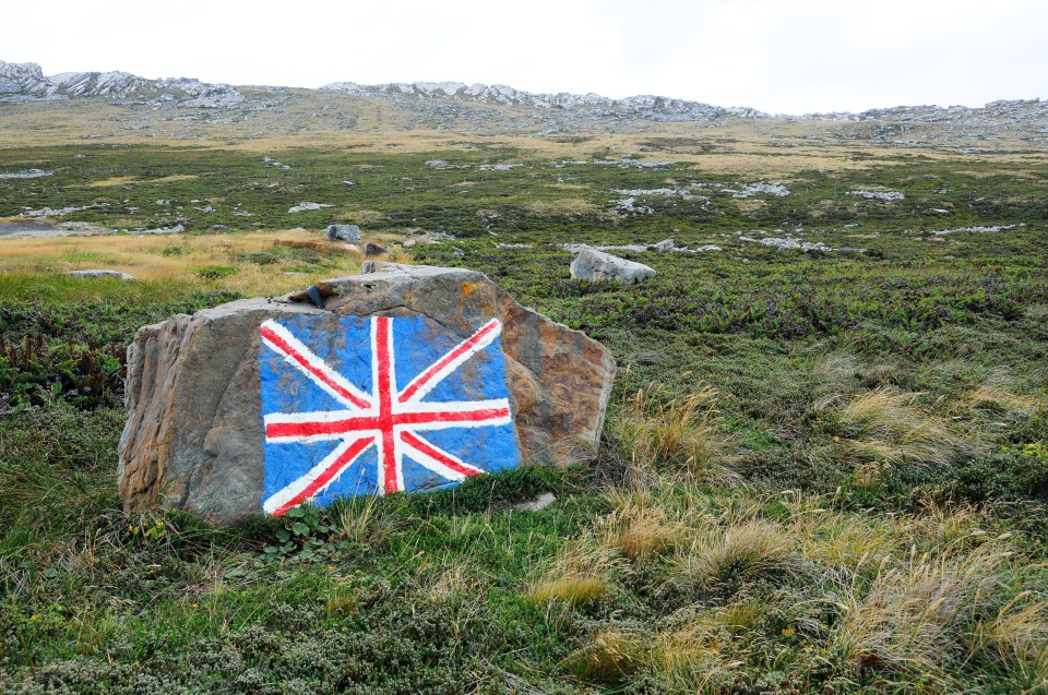 Union Flag painted on a rock in a barren landscape.