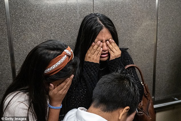 The family held onto their father and husband as he was torn away by masked agents