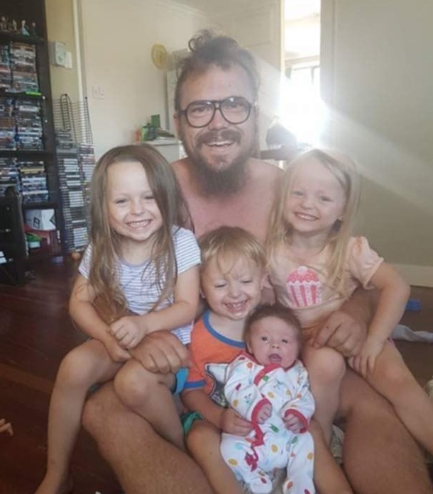 Father with four children sitting on the floor.
