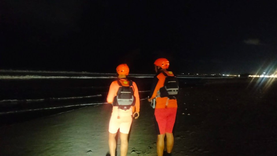Rescue teams searching for a tourist at Legian Beach, Bali at night.