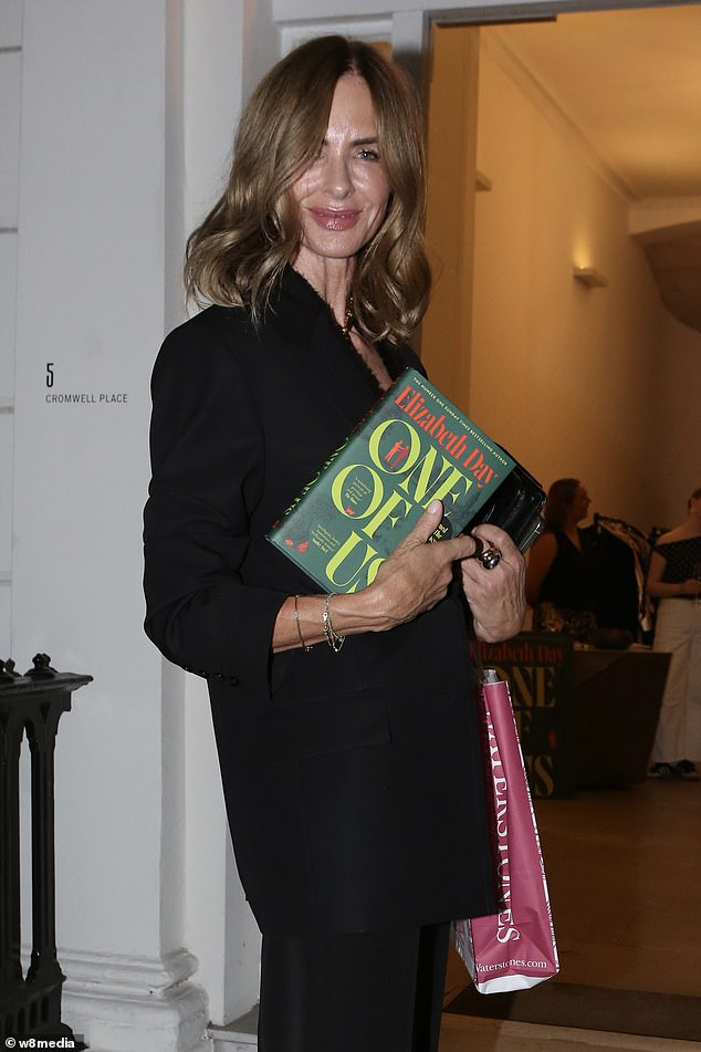 Meanwhile beaming Trinny, 61, looked typically classy in a black suit as she posed for snaps holding a copy of the book outside the lavish location