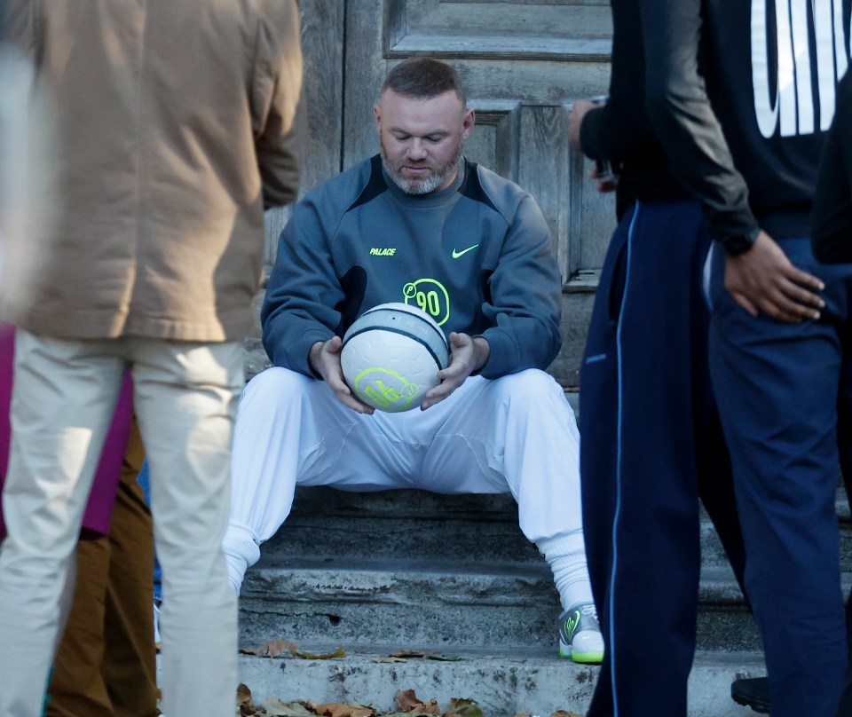 Wayne Rooney holding a football in a Palace Skateboards music video.