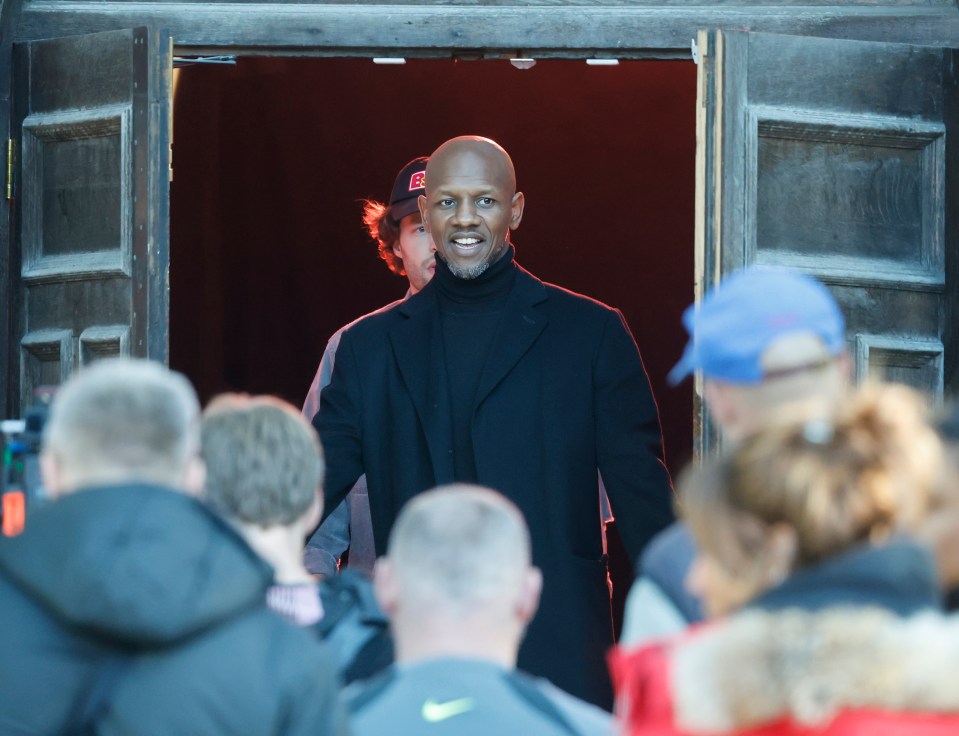 UK rap star K-Trap stands in an open doorway.