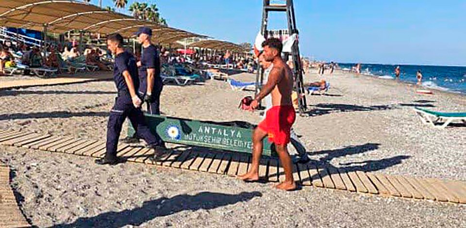 Lifeguards carrying a stretcher on a beach in Kemer, Antalya.