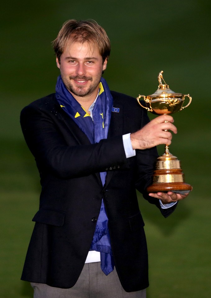 Victor Dubuisson posing with the Ryder Cup trophy.