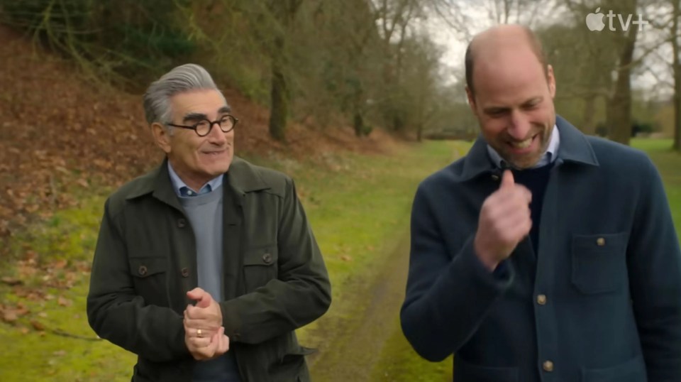 Eugene Levy and Prince William walking together on a path.