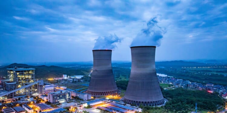 Thermal nuclear power plant cooling towers at dusk.