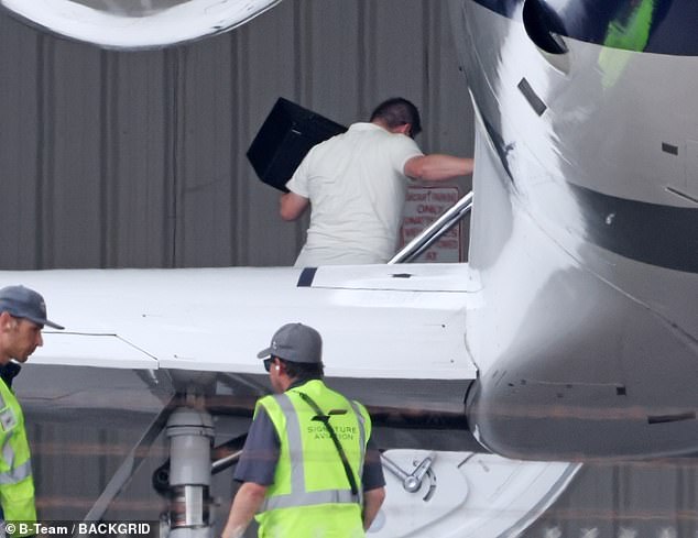 Her security could be seen unloading a few small bags from her plane as well as carefully handling a garment bag and one handler carried a large white box