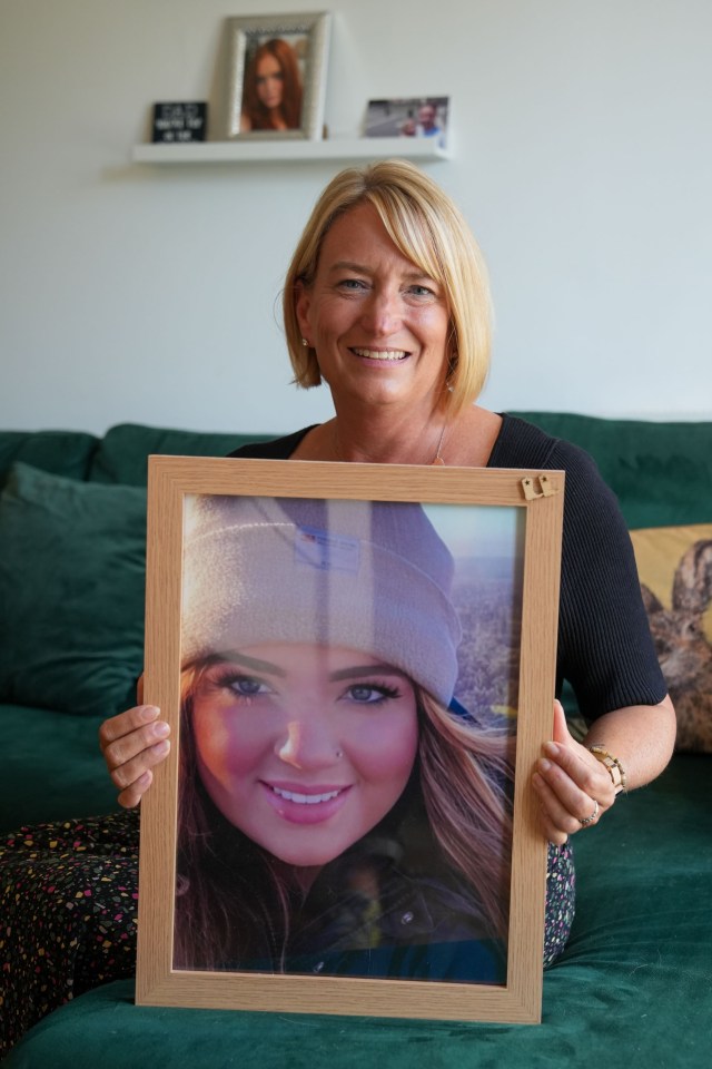 Hannah's mother, Sarah Warner, holding a framed photograph of Hannah.