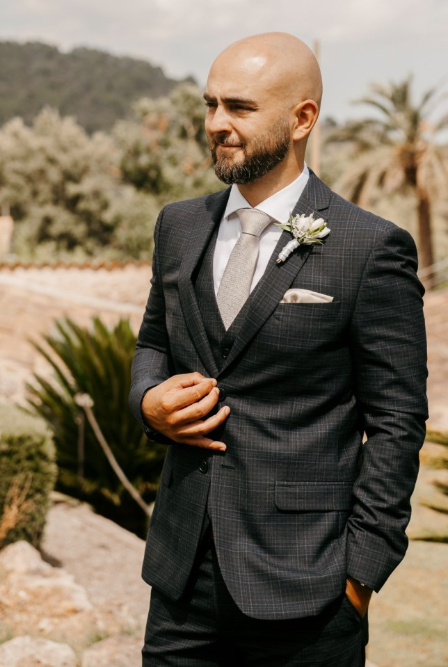 Nick Barnard in a dark gray plaid suit.