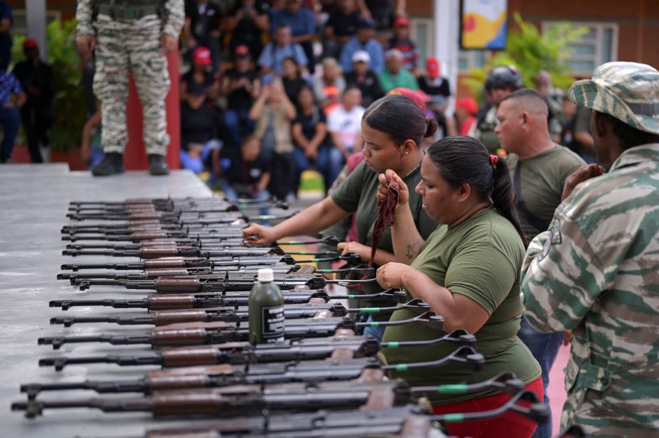 Two women, participating in a Bolivarian National Armed Forces drill, train with weapons alongside other citizens in Caracas, Venezuela.