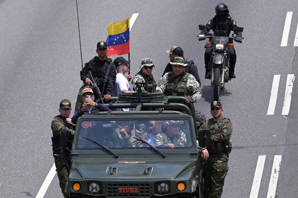 Venezuela's Interior Minister Diosdado Cabello in the driver's seat of a military vehicle, participating in a drill to train citizens in weapons handling.