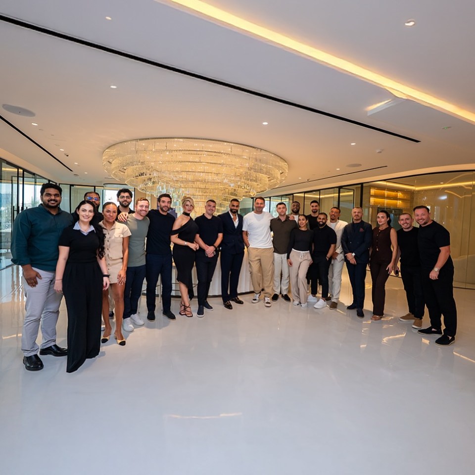 A large group of men and women from Kamani Living posing for a picture in a luxurious room.