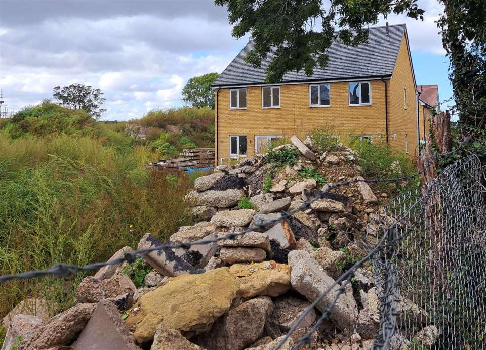 Abandoned housing estate with rubble in the foreground.
