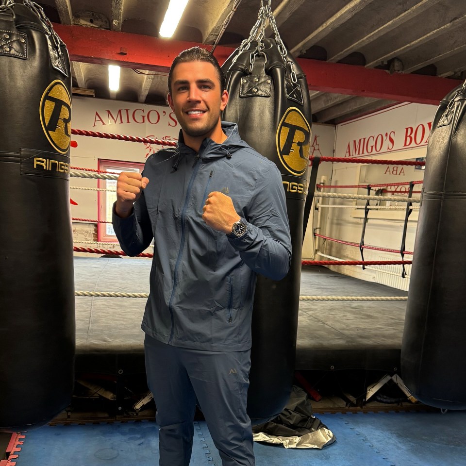Jack Fincham in a boxing gym with punching bags and a ring.