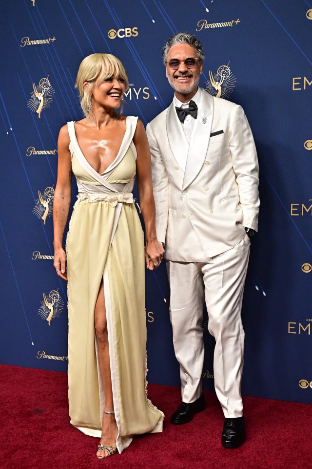 Taika Waititi and Rita Ora pose on the red carpet at the 77th Primetime Emmy Awards.