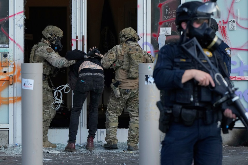 U.S. Customs and Border Protection agents detain a man outside the U.S. Immigration and Customs building during a protest.