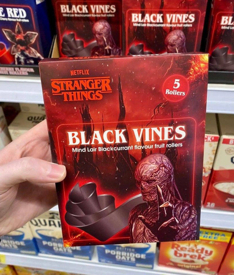 Hand holding a box of "Stranger Things Black Vines" blackcurrant fruit rollers.