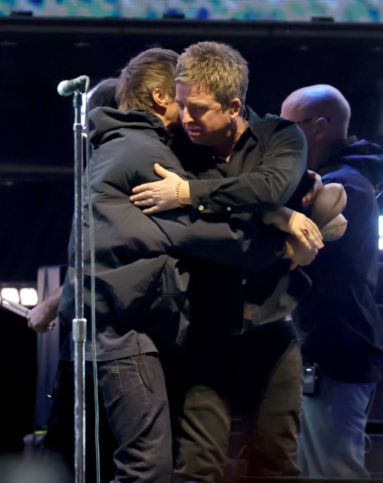 Liam Gallagher and Noel Gallagher of Oasis performing onstage.