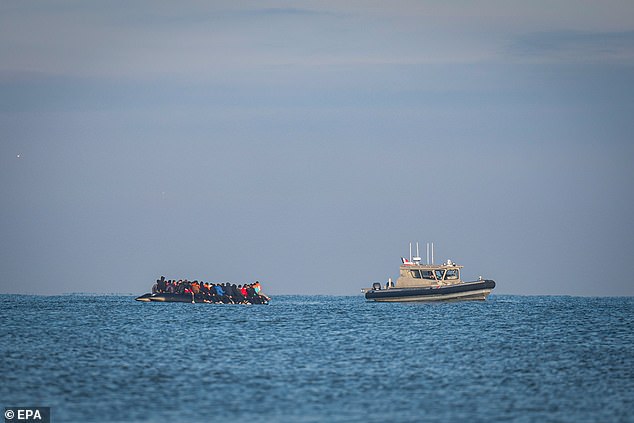 A French Coats Guard boat (R) patrols as migrants onboard an inflatable boat attempt to cross the English Channel, off the beach of Gravelines, northern France, 27 September 2025