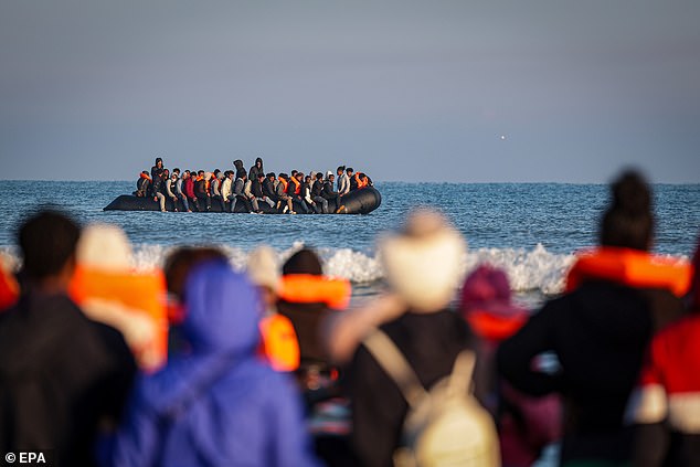 Migrants arrive on a beach to board an inflatable boat during an attempt to cross the English Channel, off the beach of Gravelines, northern France, 27 September 2025