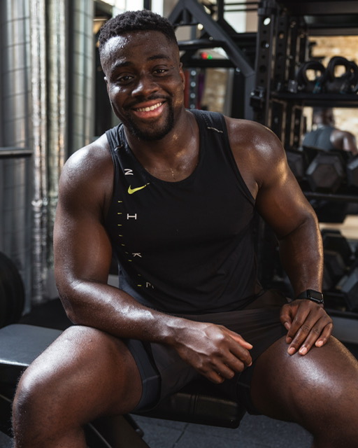 Will Duru, personal trainer and strength and conditioning coach, smiling in a gym.