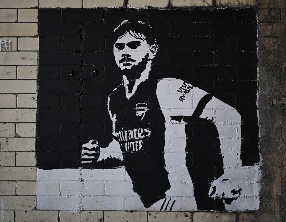A black and white mural of Billy Vigar in an Arsenal kit.