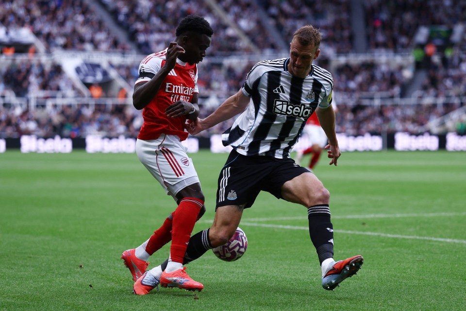 Arsenal's Bukayo Saka in action with Newcastle United's Dan Burn.