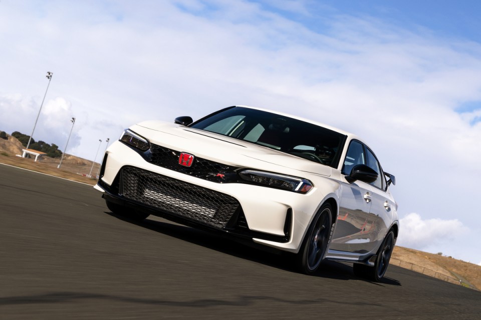 A white Honda Civic Type R driving on a racetrack.