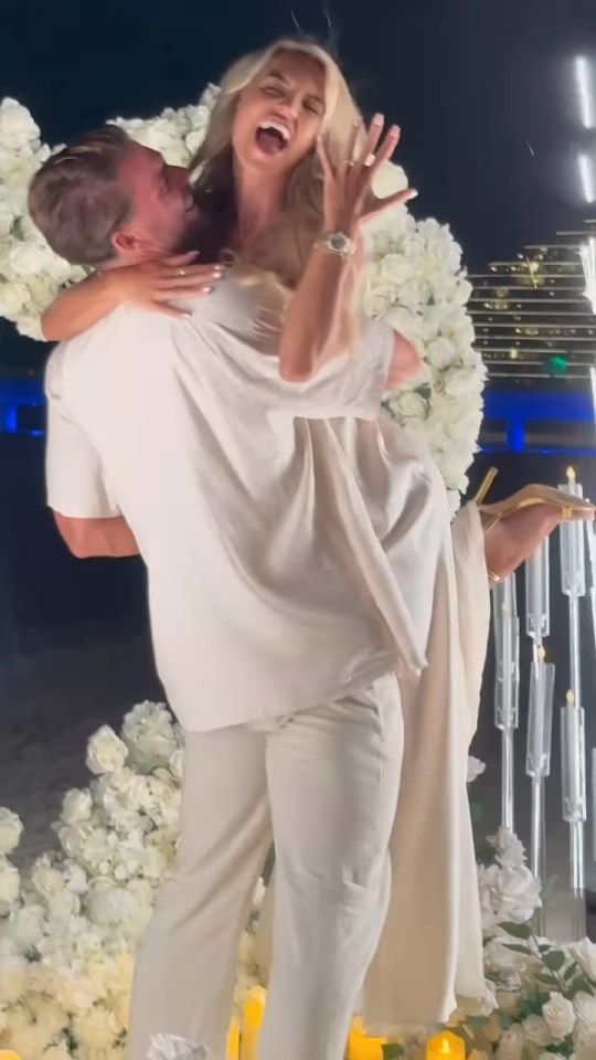 Tom Clare holding Molly Smith as she celebrates his romantic proposal.