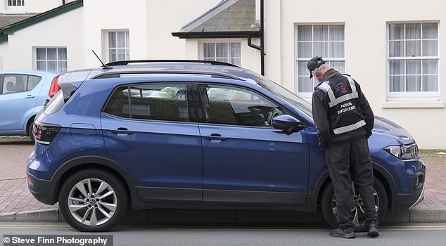 Stats show from 2021 to 2024, the number of penalty charge notices (PCNs) issued by the council increased by a shocking 216 per cent, from 36,587 to 115,741. Pictured: A traffic enforcement officer placing a ticket on a vehicle in the town this weekend