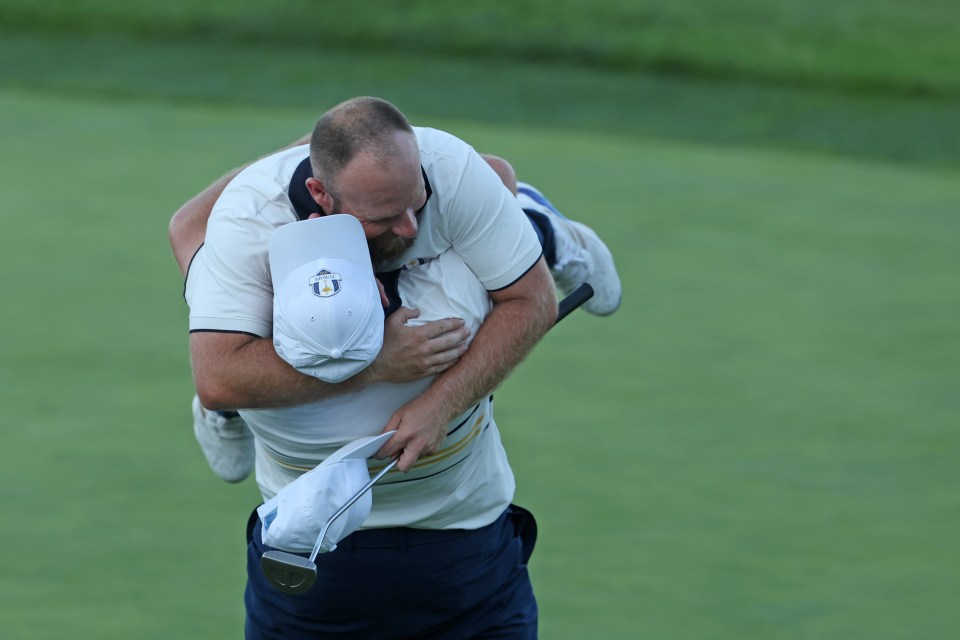 Shane Lowry of Team Europe lifts teammate Tyrrell Hatton after Hatton halved his match to win the Ryder Cup.