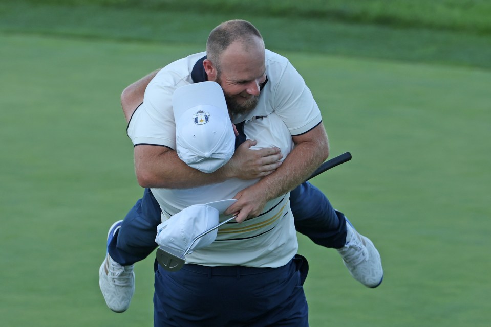 Shane Lowry of Team Europe lifts teammate Tyrrell Hatton after Hatton halved his match to win the Ryder Cup.