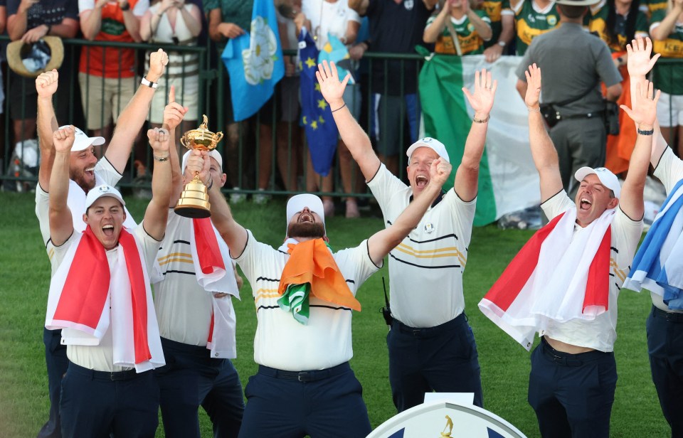 Team Europe golfers celebrate winning the Ryder Cup, with some holding flags and one holding the trophy.