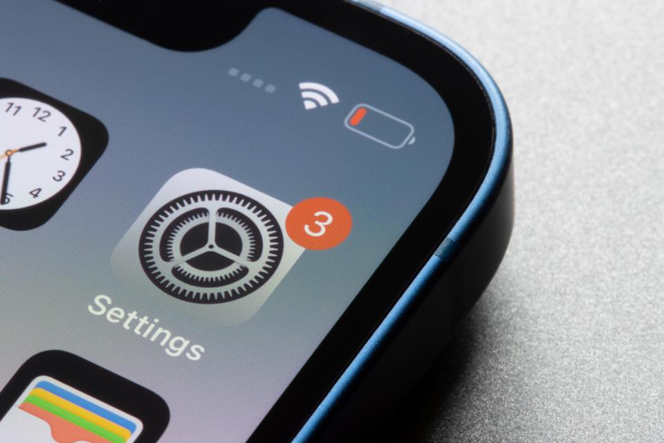 Close-up of an iPhone screen showing the Settings app icon with a notification badge.